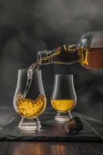 Presentación gastronómica de whisky Port Charlotte 10 años junto a una copa.